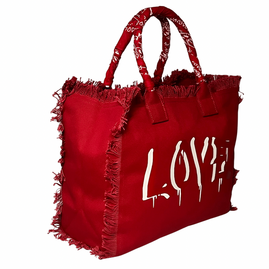 Dripping LOVE Shoulder Tote - Red/White
We have improved this best-selling bag! Now larger and roomier it's a shoulder tote and fully lined too! Fringe Bag Perfect everyday bag! - We say around here that you are just, "dripping LOVE" Fully lined canvas tote with soft-support bottom and bandana covered handles. Inside bag has 1 convenient inside zippered pockets and 2 insert pockets. Bag handles are at 7.5" drop and fits comfortably around the shoulder. Dimensions: 12"X14"X6.5" Made in USA Tee shirt availabl